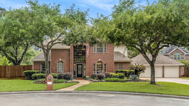 view of front of property featuring an attached garage, fence, a front yard, and concrete driveway