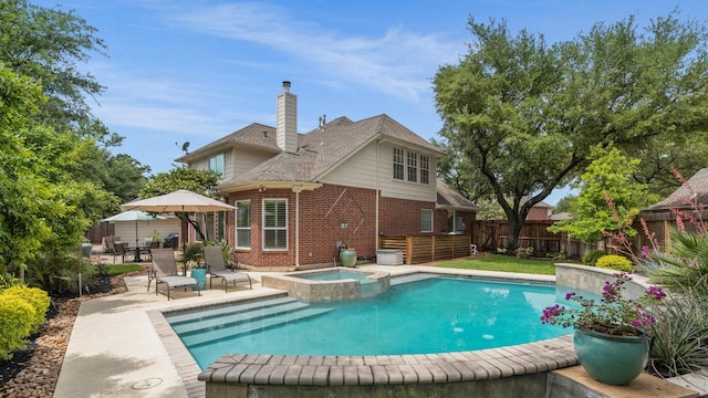 view of swimming pool featuring a patio, a pool with connected hot tub, and a fenced backyard