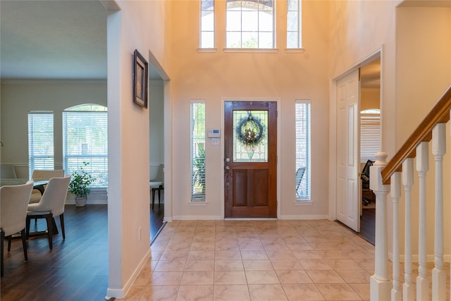 foyer entrance with plenty of natural light, stairs, and baseboards