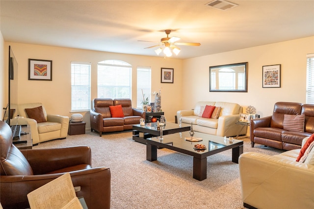 living room with carpet floors, a ceiling fan, visible vents, and plenty of natural light