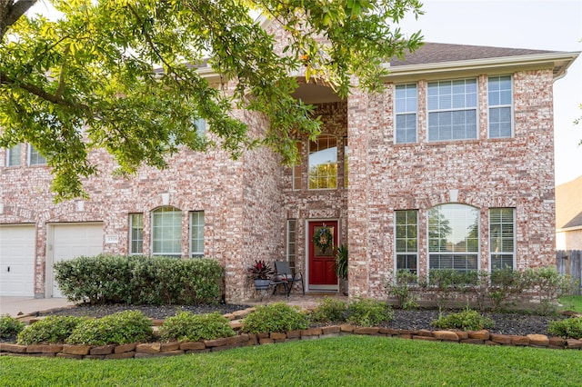 colonial-style house with a garage, concrete driveway, and brick siding