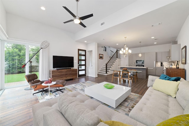 living room featuring dark wood-style flooring, recessed lighting, visible vents, and stairway