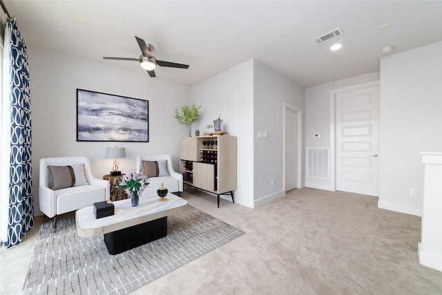 carpeted living room with ceiling fan, visible vents, and baseboards