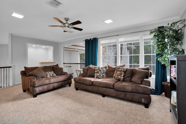carpeted living room with visible vents, crown molding, and ceiling fan