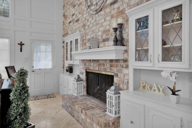 living room with a high ceiling and a brick fireplace
