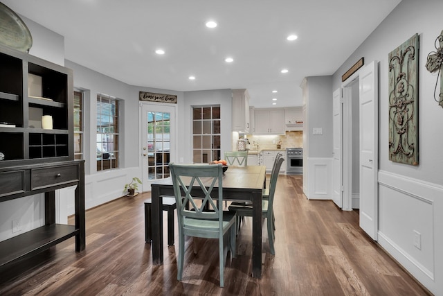 dining room with wainscoting, a decorative wall, and recessed lighting