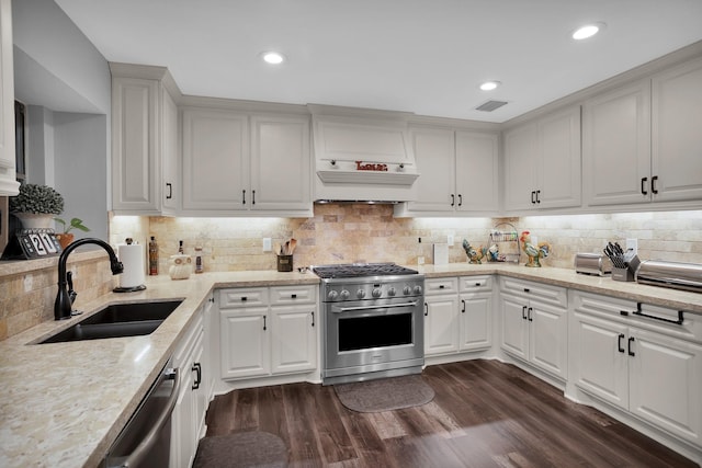 kitchen featuring appliances with stainless steel finishes, a sink, tasteful backsplash, visible vents, and custom exhaust hood