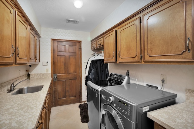 laundry area with a sink, independent washer and dryer, cabinet space, and visible vents