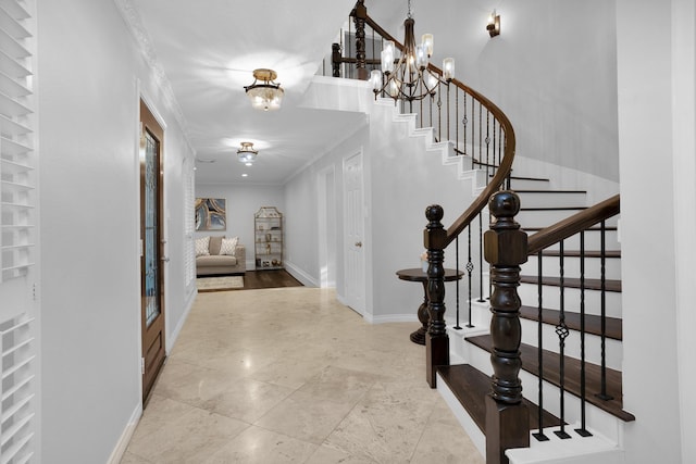 entryway featuring stairs, baseboards, a notable chandelier, and ornamental molding