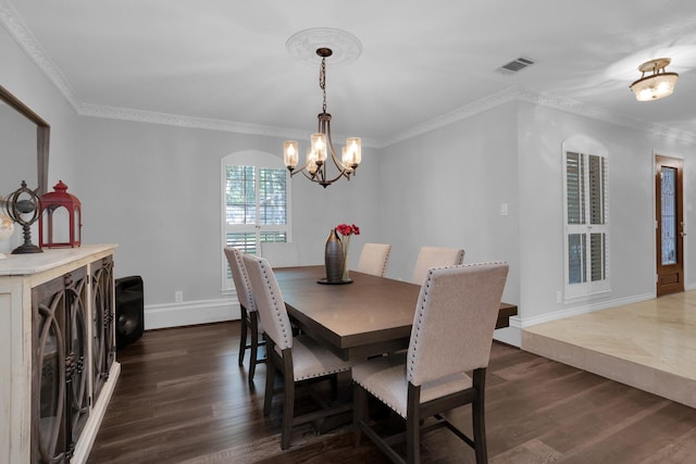 dining room with a notable chandelier, dark wood-style floors, ornamental molding, and visible vents