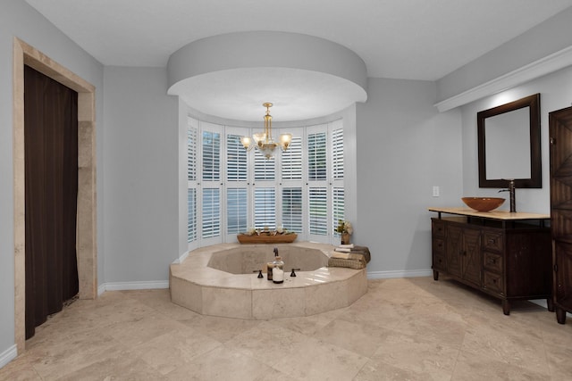 bathroom with baseboards, a bath, a chandelier, and vanity