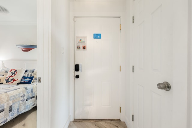 entryway featuring ornamental molding and light wood-type flooring