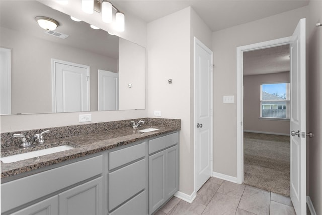 full bath featuring a sink, baseboards, double vanity, and visible vents