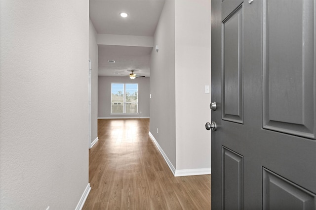 hallway with baseboards, recessed lighting, and wood finished floors