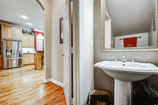 bathroom with baseboards, recessed lighting, wood finished floors, and tasteful backsplash