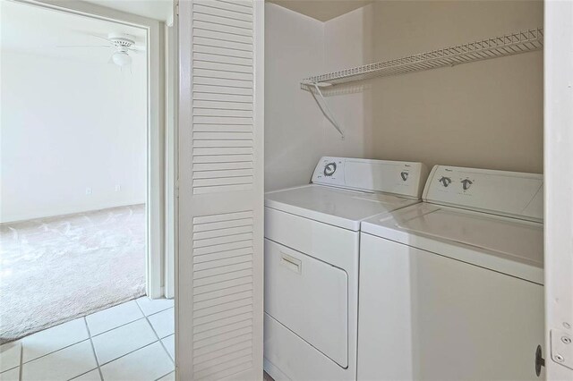 3045 Walnut Bend Ln Unit 27, Houston, TX 77042 - washroom featuring light tile patterned floors, laundry area, light carpet, and washer and clothes dryer