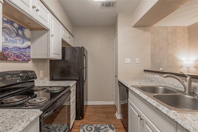 kitchen with electric range, a sink, dishwasher, white cabinetry, and visible vents