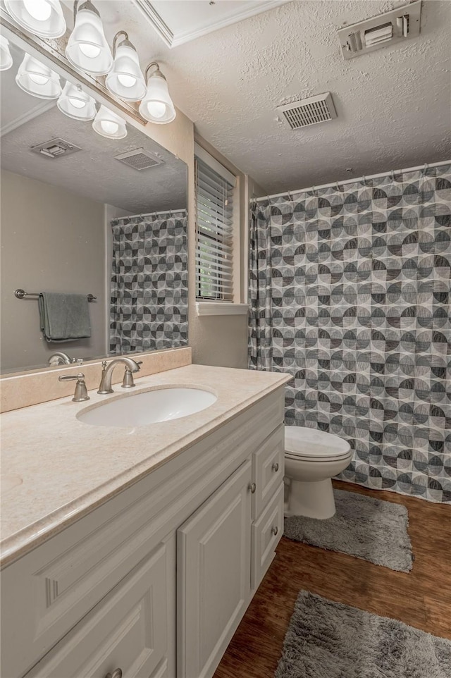 full bathroom with visible vents, wood finished floors, toilet, and vanity