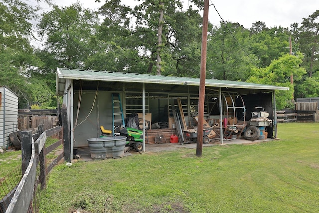 view of pole building with fence and a yard