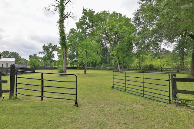 view of gate featuring fence and a lawn