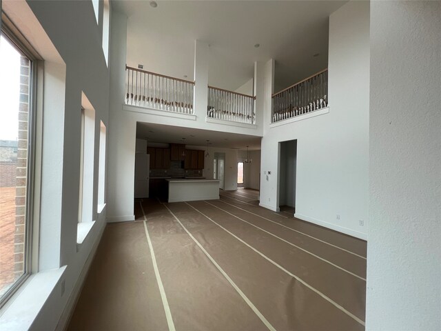 27111 Bel Air Point Ln, Katy, TX 77493 - unfurnished living room with a healthy amount of sunlight, baseboards, and a towering ceiling