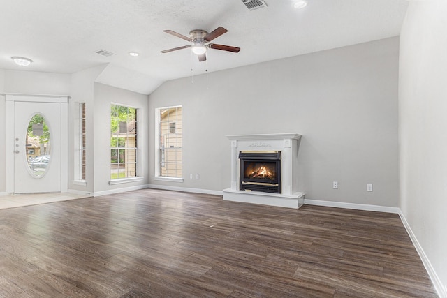 unfurnished living room featuring ceiling fan, visible vents, wood finished floors, baseboards, and a glass covered fireplace