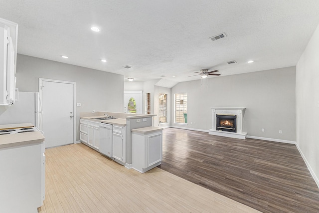 kitchen with a ceiling fan, white appliances, light countertops, a sink, and light wood-style flooring