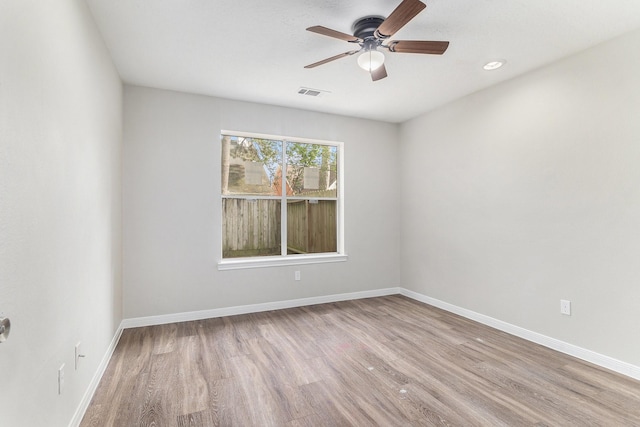 empty room featuring baseboards, ceiling fan, wood finished floors, and visible vents