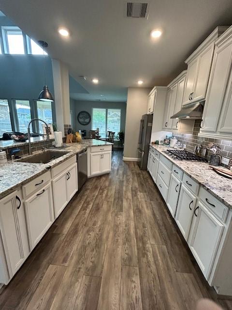 15419 Greenford Glen Dr, Cypress, TX 77429 - kitchen featuring a sink, white cabinets, visible vents, under cabinet range hood, and appliances with stainless steel finishes