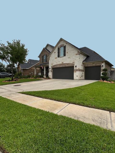 15419 Greenford Glen Dr, Cypress, TX 77429 - french country home with a front lawn, stone siding, and driveway