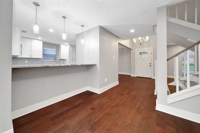1226 Westgreen Blvd, Katy, TX 77450 - kitchen with an inviting chandelier, decorative backsplash, baseboards, white cabinetry, and dark wood finished floors