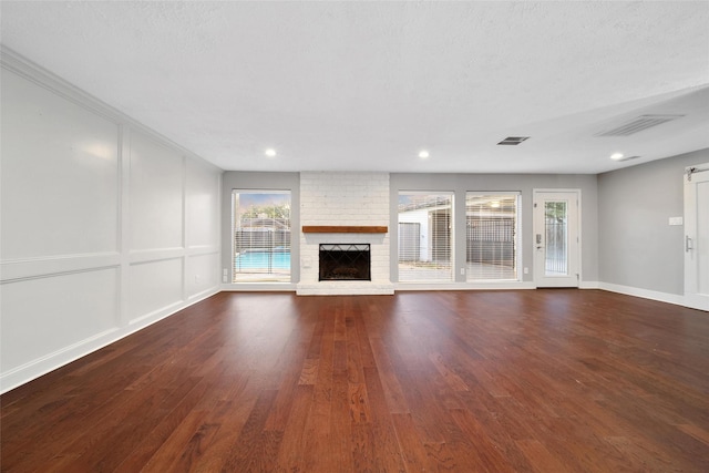 1226 Westgreen Blvd, Katy, TX 77450 - unfurnished living room with recessed lighting, visible vents, dark wood-type flooring, and a fireplace