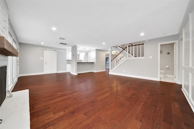 1226 Westgreen Blvd, Katy, TX 77450 - unfurnished living room with a fireplace, stairs, baseboards, wood finished floors, and visible vents