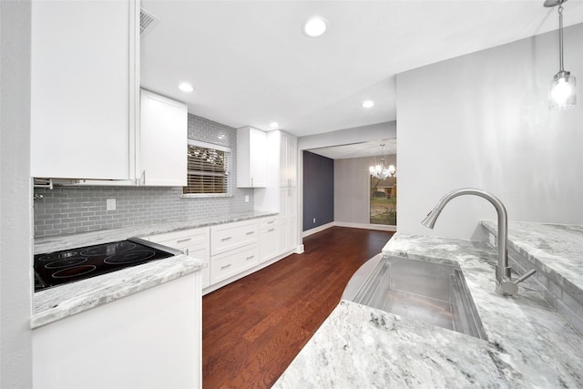 1226 Westgreen Blvd, Katy, TX 77450 - kitchen featuring white cabinets, light stone counters, a sink, dark wood finished floors, and recessed lighting
