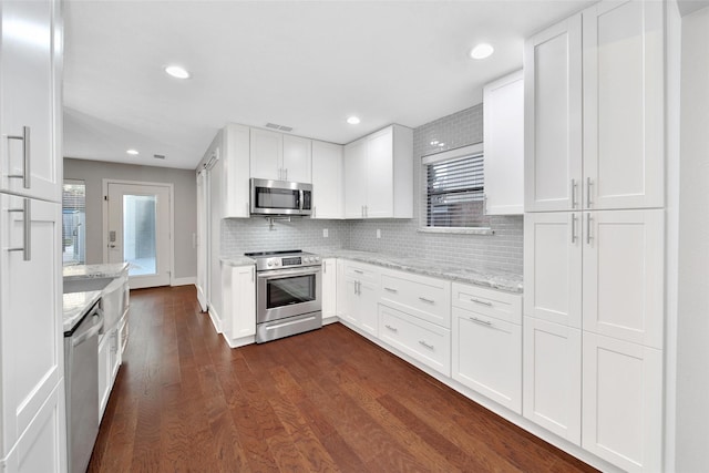 1226 Westgreen Blvd, Katy, TX 77450 - kitchen with white cabinets, appliances with stainless steel finishes, dark wood-style floors, and tasteful backsplash