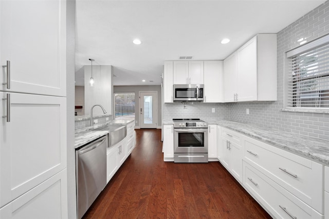 1226 Westgreen Blvd, Katy, TX 77450 - kitchen featuring decorative backsplash, light stone countertops, a sink, dark wood-style floors, and stainless steel appliances