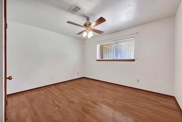 unfurnished room with a ceiling fan, baseboards, visible vents, and wood finished floors