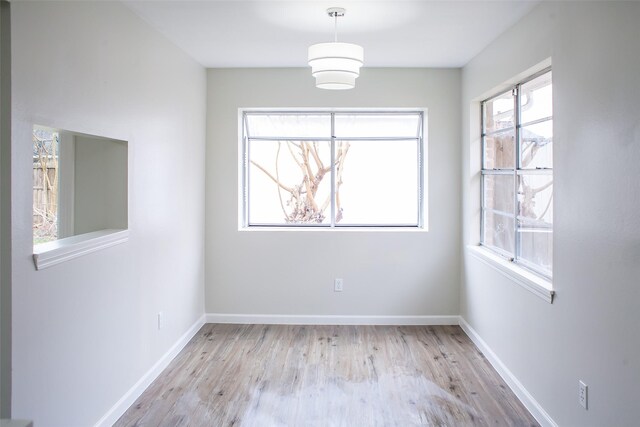 1222 Lynn Ln, Humble, TX 77338 - unfurnished dining area with baseboards and light wood finished floors