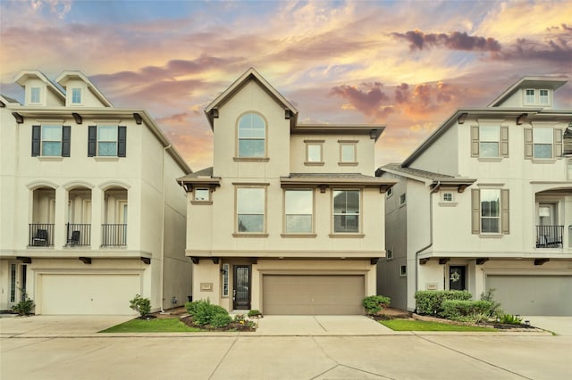 multi unit property with a garage, stucco siding, and concrete driveway