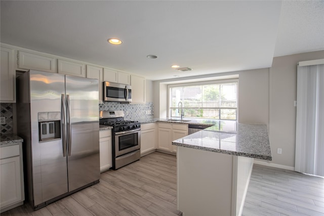 11306 Chiselhurst Way Ct, Houston, TX 77065 - kitchen with a sink, stainless steel appliances, a peninsula, decorative backsplash, and visible vents
