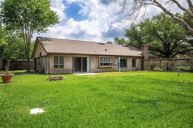 11306 Chiselhurst Way Ct, Houston, TX 77065 - rear view of property featuring roof with shingles, a lawn, brick siding, a fenced backyard, and an outdoor fire pit
