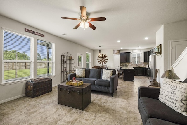 living area featuring a ceiling fan, visible vents, light tile patterned floors, baseboards, and recessed lighting
