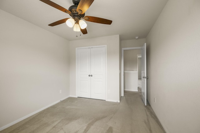 unfurnished bedroom featuring baseboards, ceiling fan, carpet, and a closet
