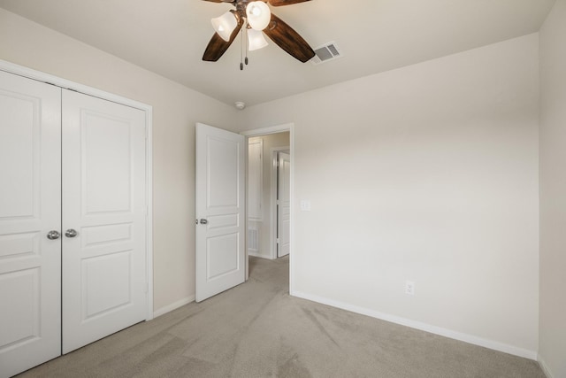 unfurnished bedroom featuring baseboards, light carpet, a closet, and visible vents
