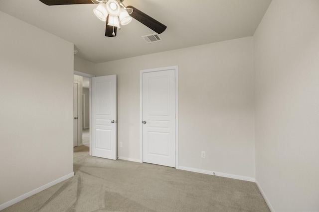 unfurnished bedroom with baseboards, ceiling fan, carpet, and visible vents
