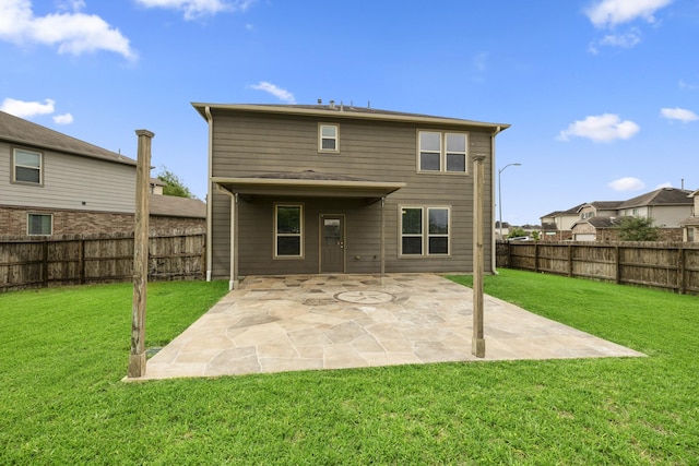 rear view of property featuring a patio, a fenced backyard, and a yard