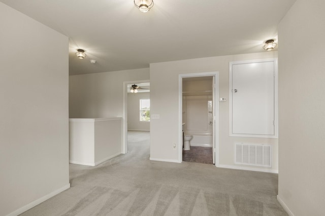 unfurnished room featuring visible vents, a ceiling fan, baseboards, and carpet floors