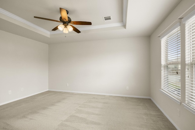 empty room featuring ornamental molding, light carpet, ceiling fan, and visible vents
