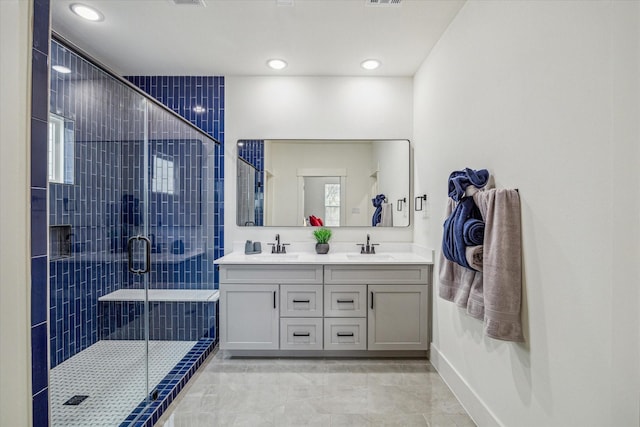 full bathroom with double vanity, a stall shower, recessed lighting, baseboards, and marble finish floors