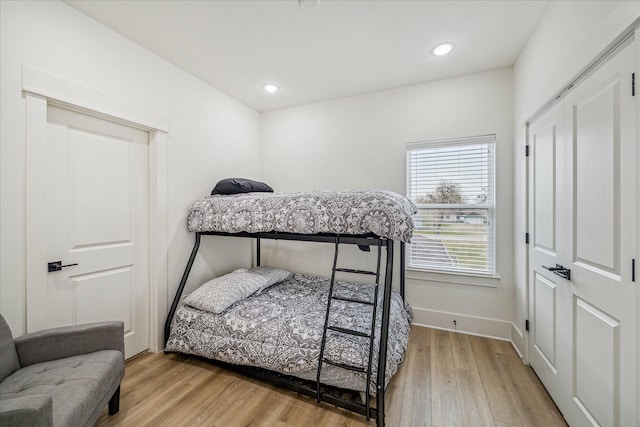 bedroom with wood finished floors, baseboards, and recessed lighting